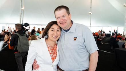 Doug and Susan Massick, arm in arm, under a tent at Reunions in 2023