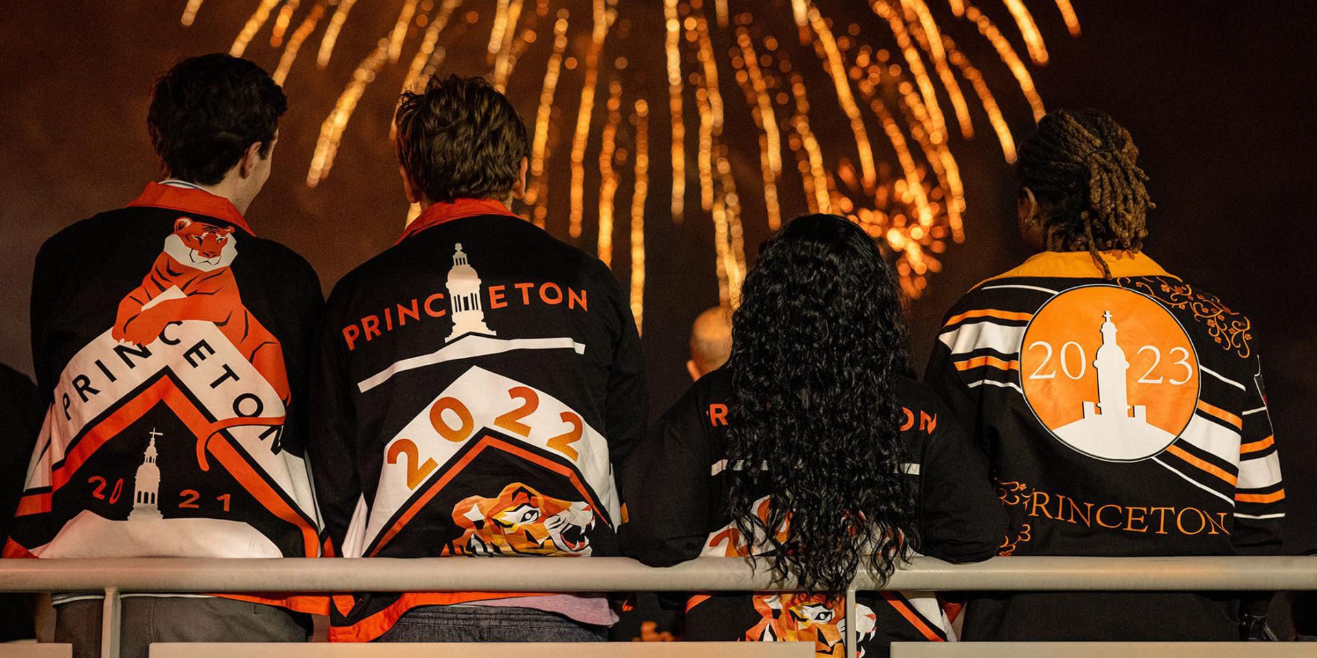 Fireworks explode above as young alumni watch during Reunions
