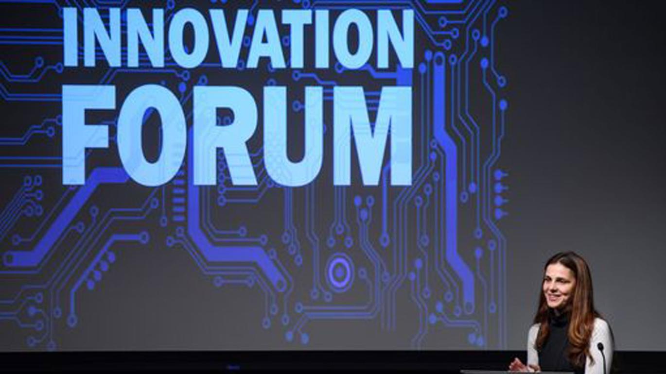 Innovation Forum with woman at lectern