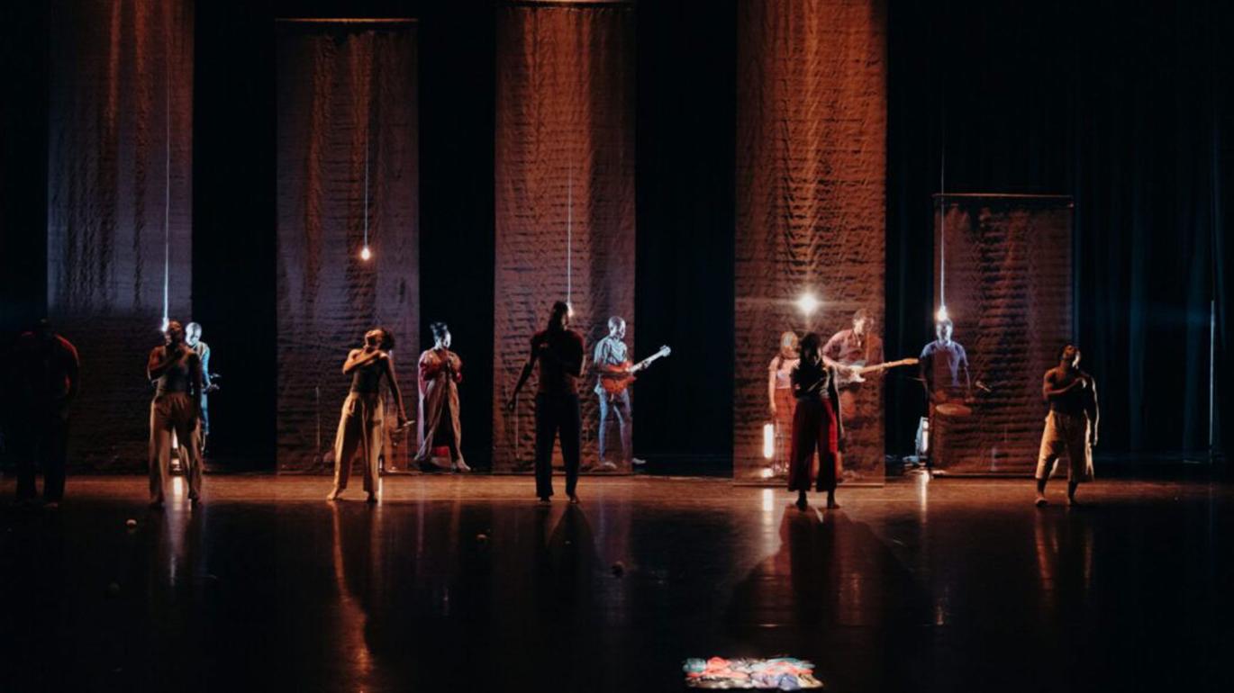 Group of people dancing in a dark room with spotlights