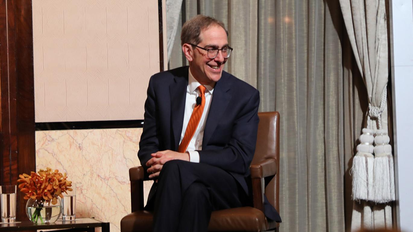 President Eisgruber, smiling on stage of a Venture Forward event