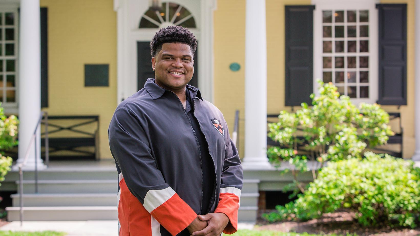 Eric Plummer from the Class of 2010, standing in front of Maclean House on the Princeton campus