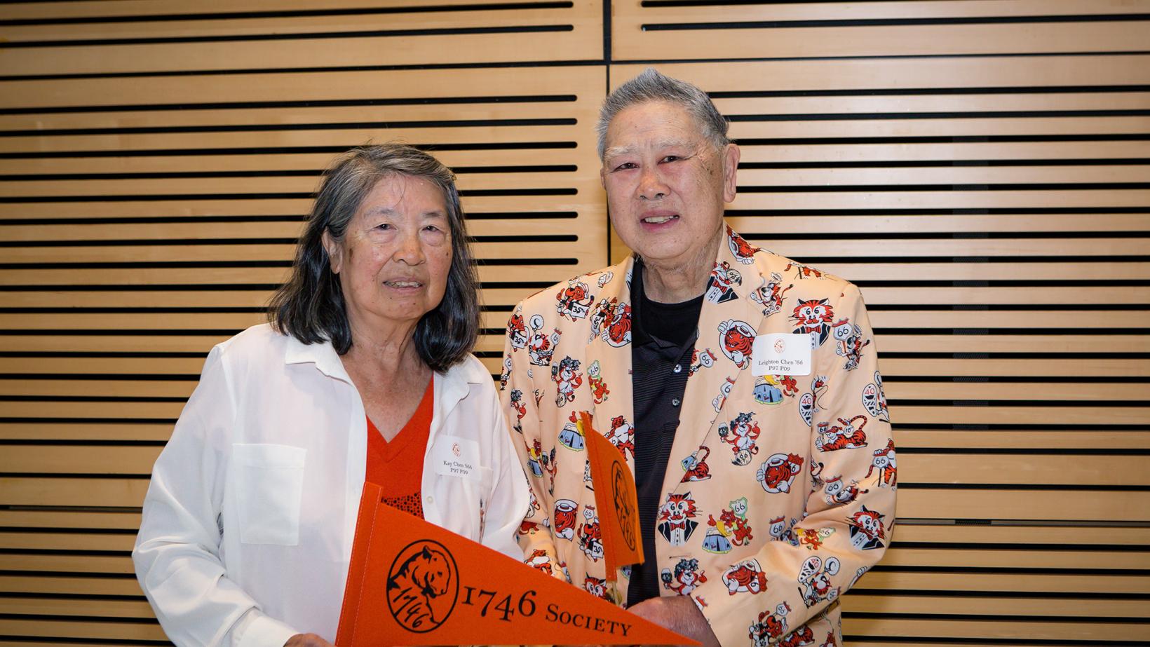 Kay and Leighton Chen, holding an orange Princeton pennant
