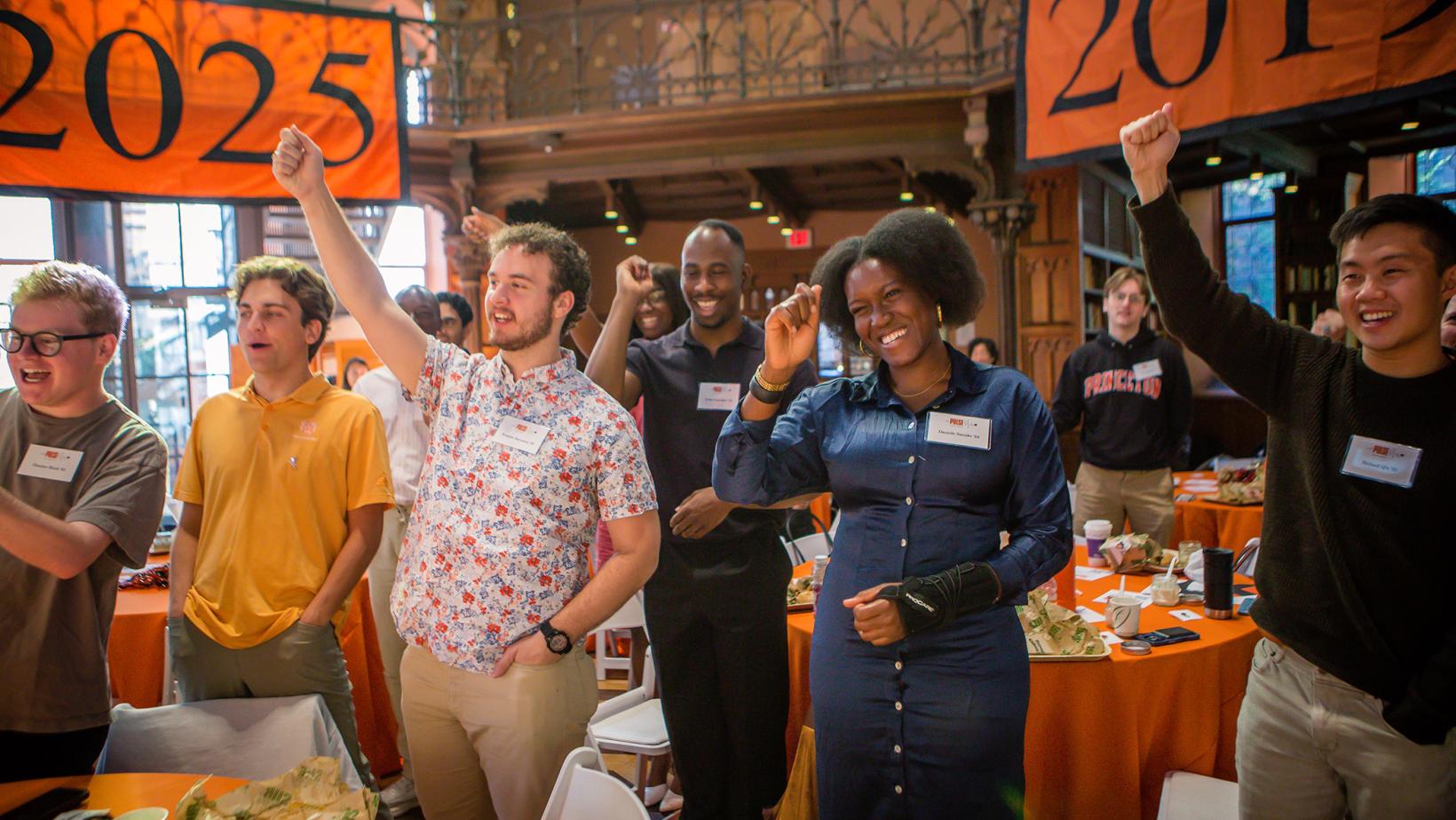 Recent alumni stand in a Locomotive cheer