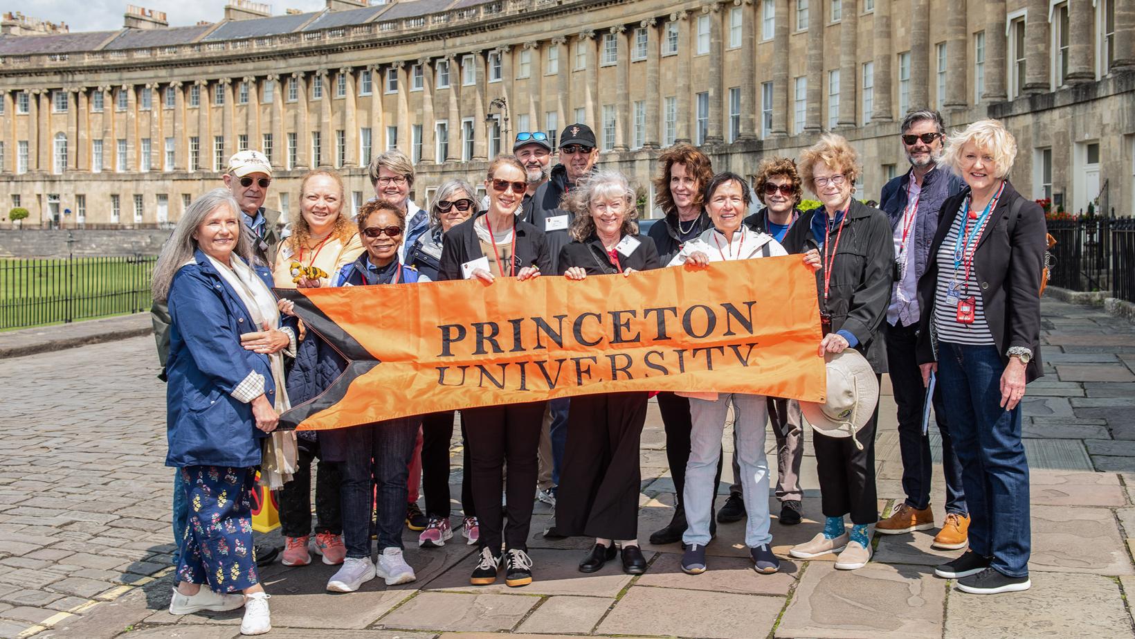 Princeton alumni and friends hold an orange Princeton banner in front of No. 1 Royal Crescent, part of the Jane Austen tour