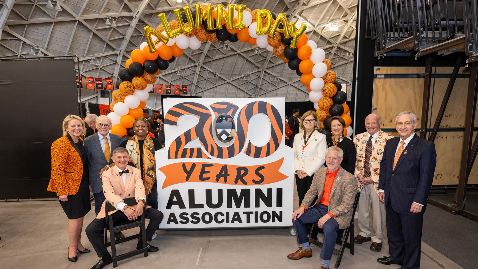 Ryan Ruskin and former chairs of the Alumni Council crowd around the form sculture celebrating the 200th anniversary of the Alumni Association.