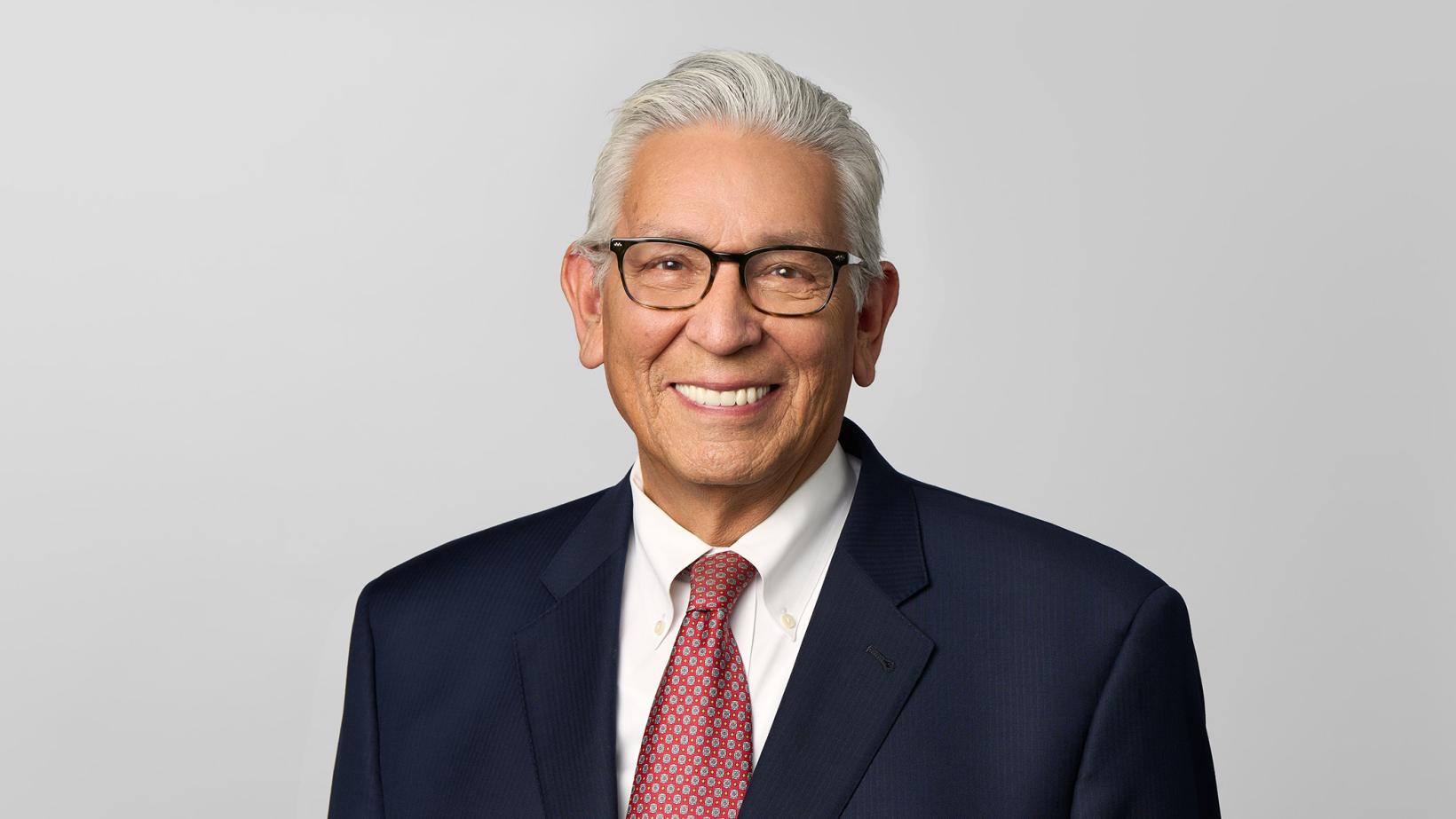 Kevin Gover smiling, wearing glasses and tie. 