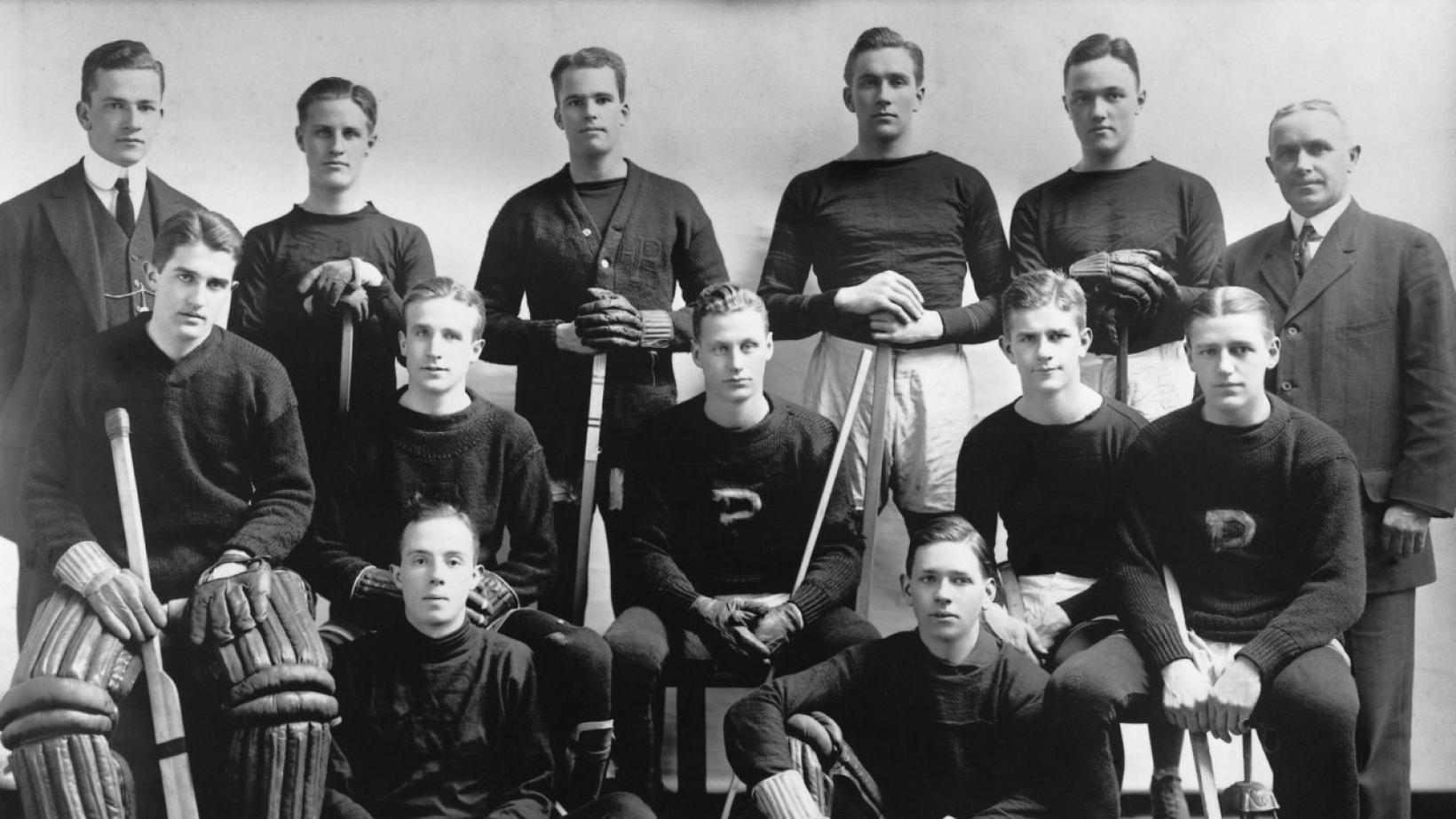 Black and white team photo of the Princeton ice hockey team, with Hobey Baker seated in the middle
