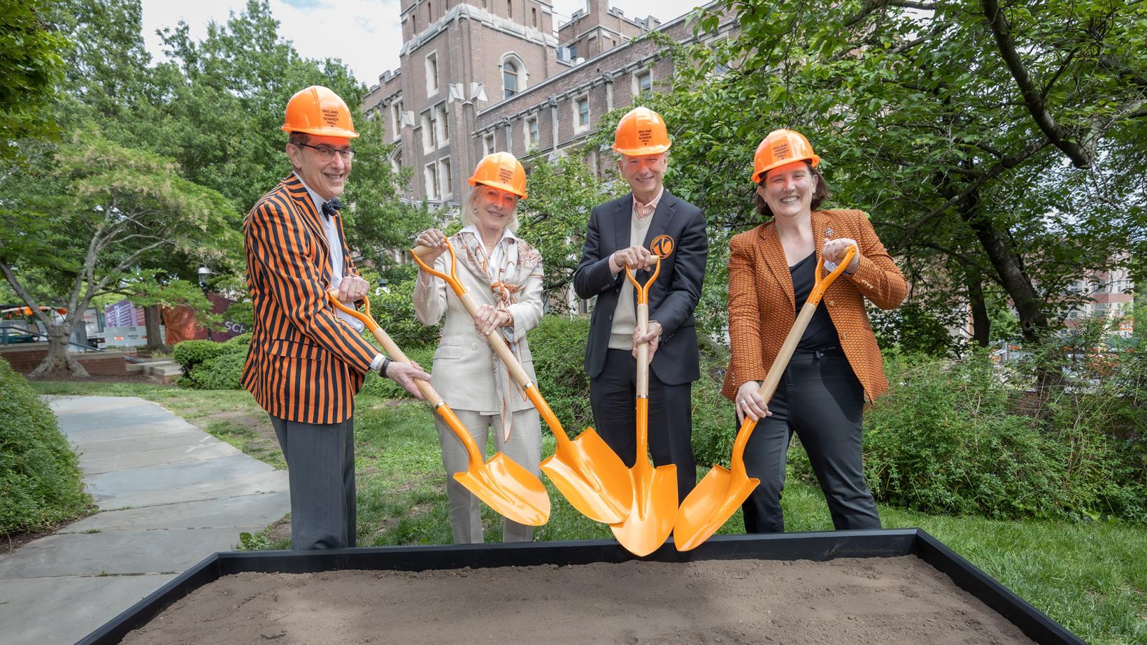President Eisgruber, Wendy and Eric Schmidt, and Jen Rexford don orange hard hats and grab orange shovels for a ceremonial groundbreaking