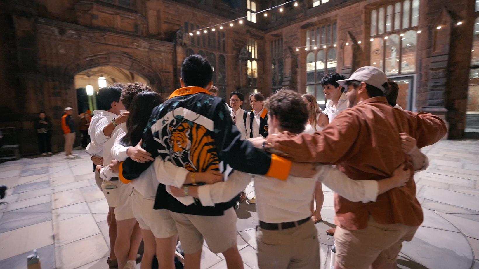 Princeton alumni in a circle, with arms around each other.