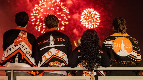 Three young alumni watch the fireworks at Reunions