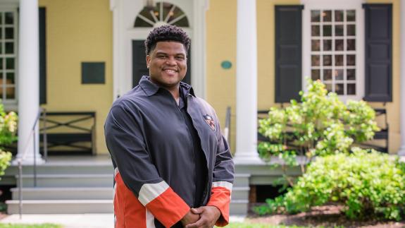 Eric Plummer from the Class of 2010, standing in front of Maclean House on the Princeton campus