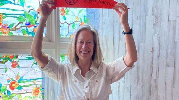 Beth Gilson holds a 1746 Society pennant