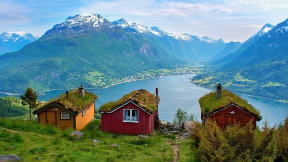 Three cottages overlooking a river and mountains