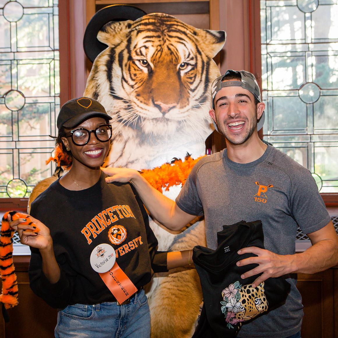 Two Princeton alumni posing in front of a cardboard tiger