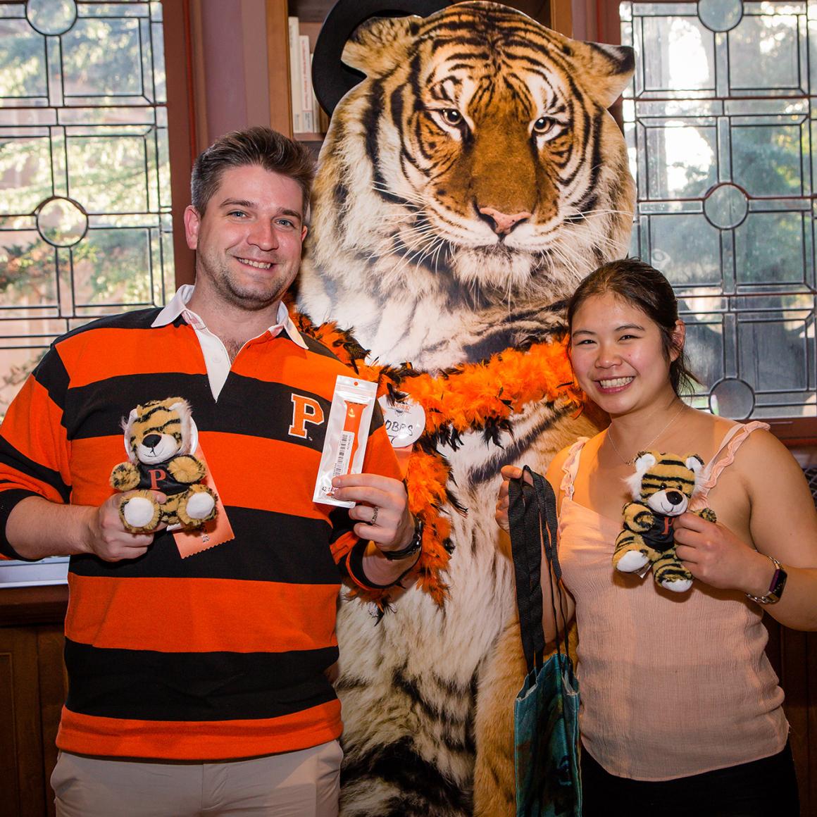 Two Princeton alumni pose in front of a cardboard tiger.