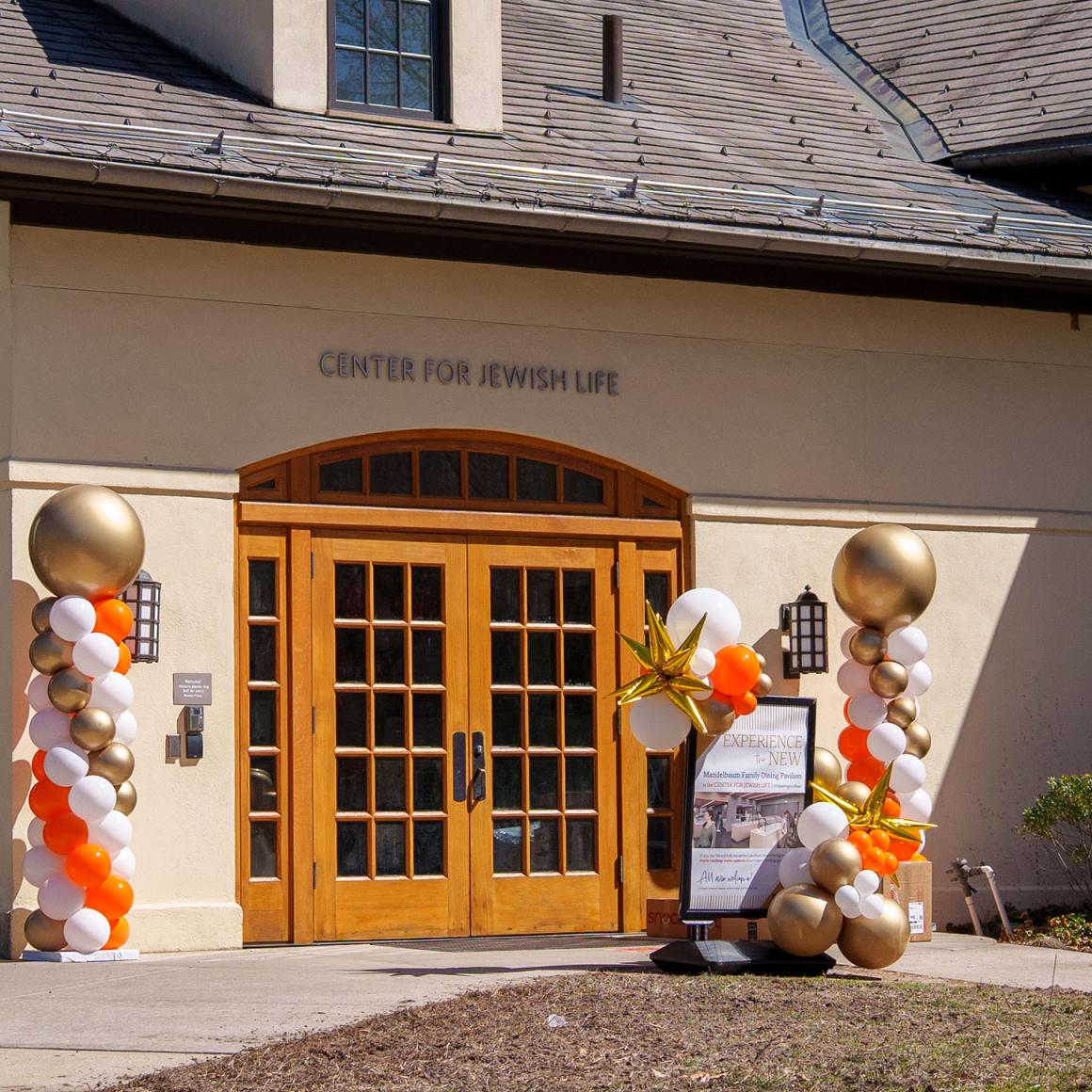 The front doors of the Center for Jewish Life with balloons and a sign on the opening day of the new pavilion