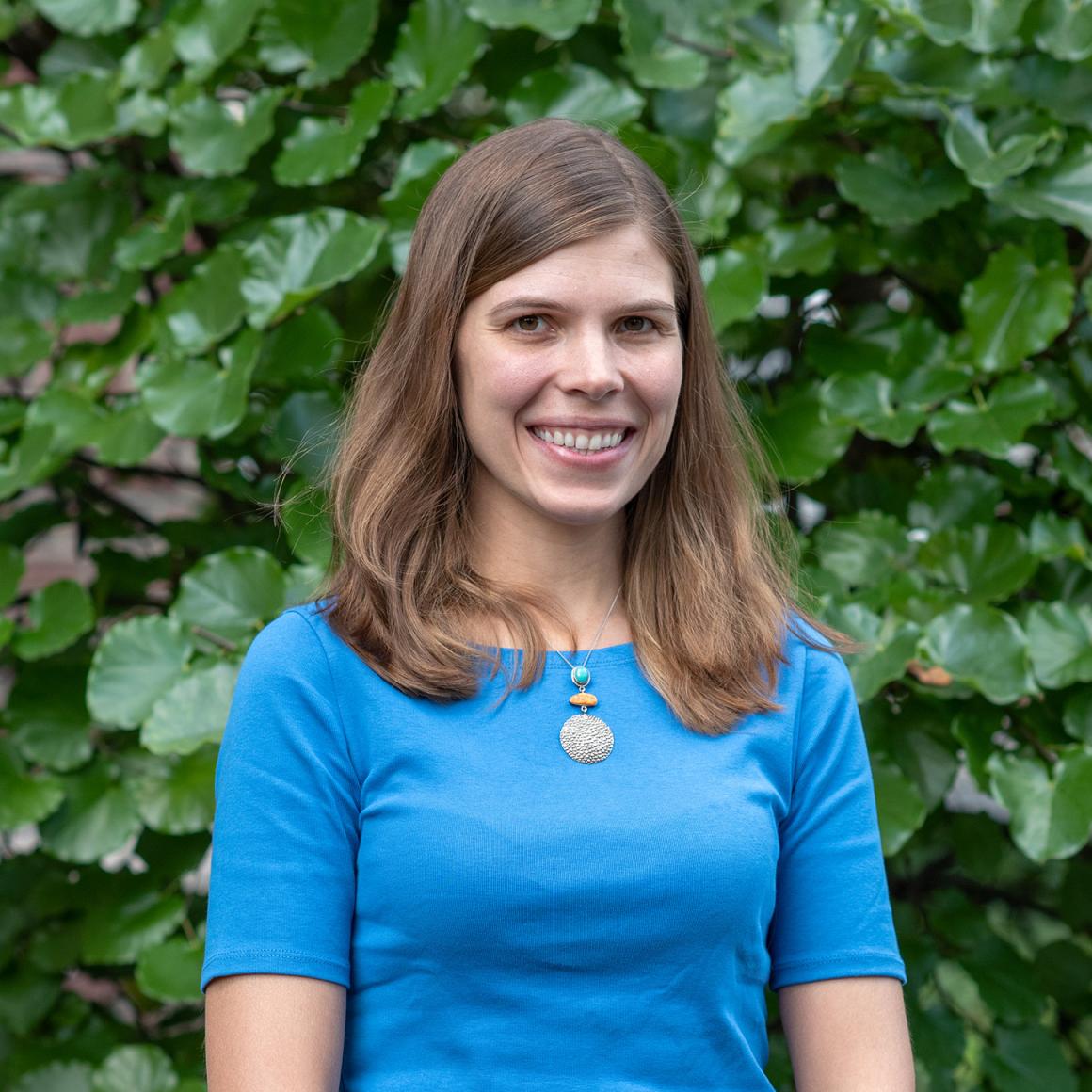 Cassie Stoddard, standing in front of a wall of ivy