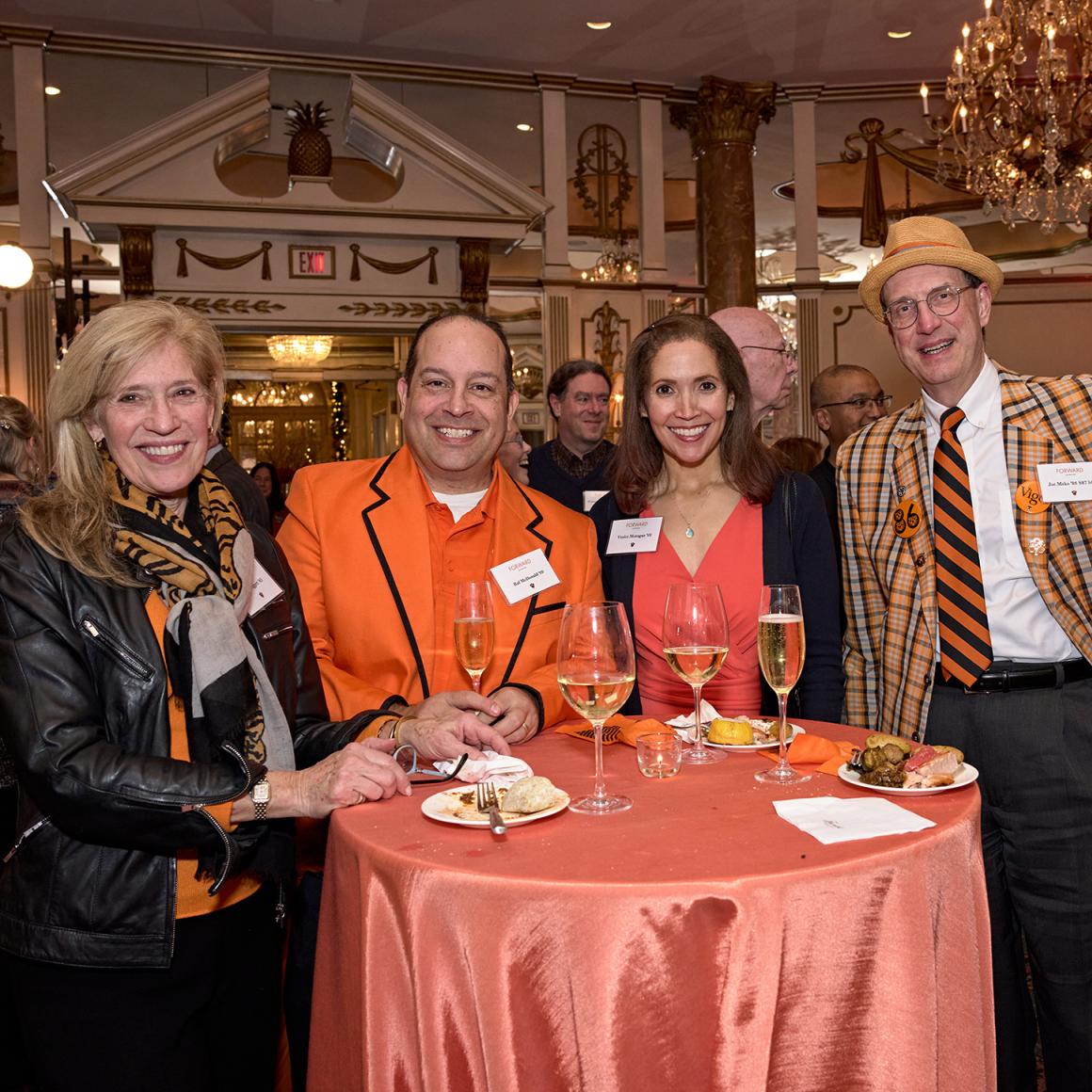 Four Princeton alumni gathered around a standing-table.