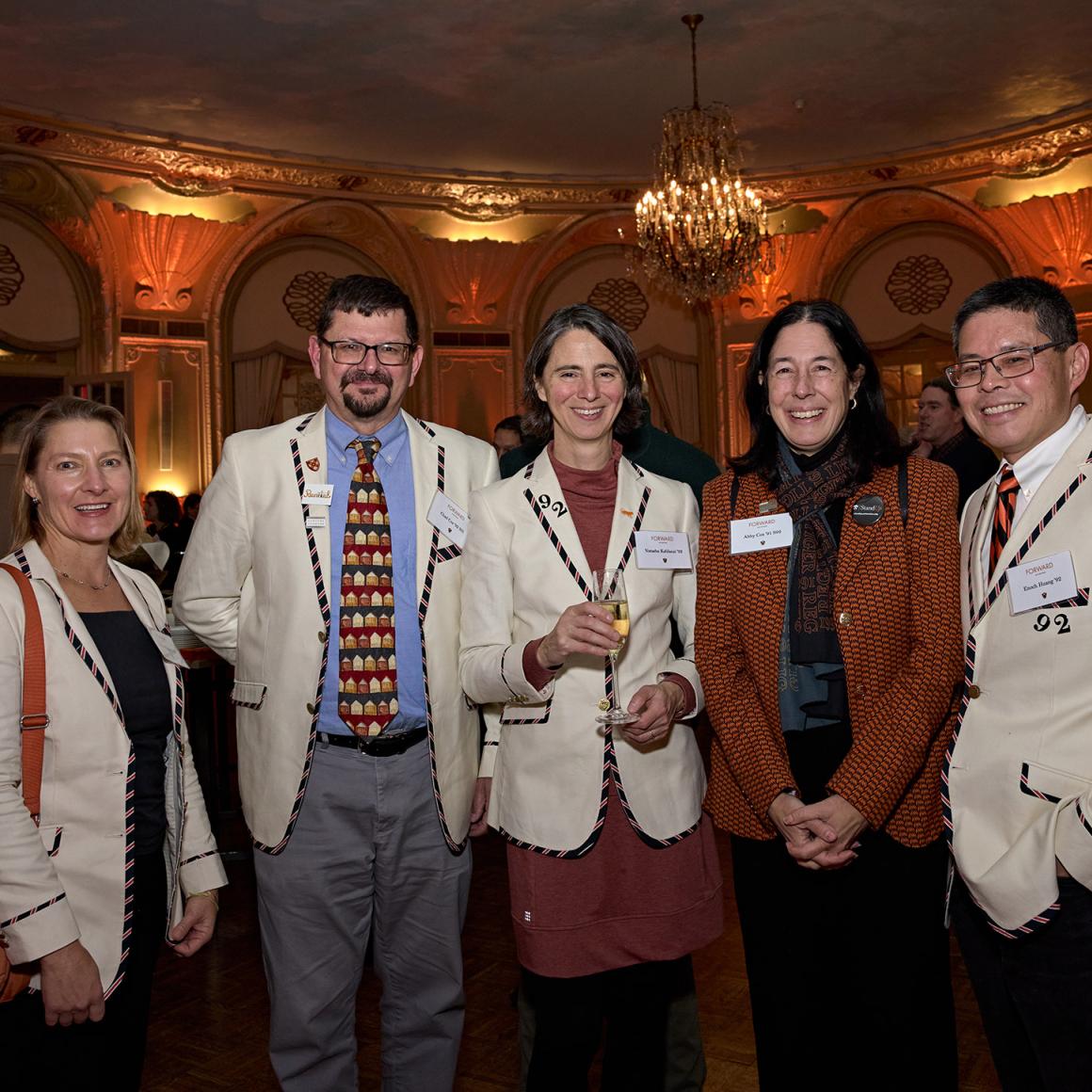 Five alumni, each wearing their Princeton class jacket, posing together at the Boston event.
