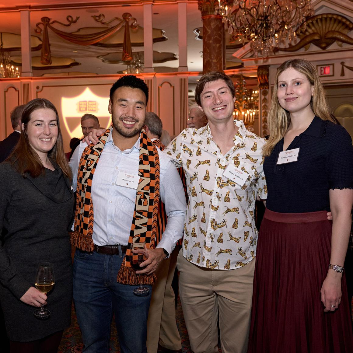 Four alumni posing together at the Boston event.
