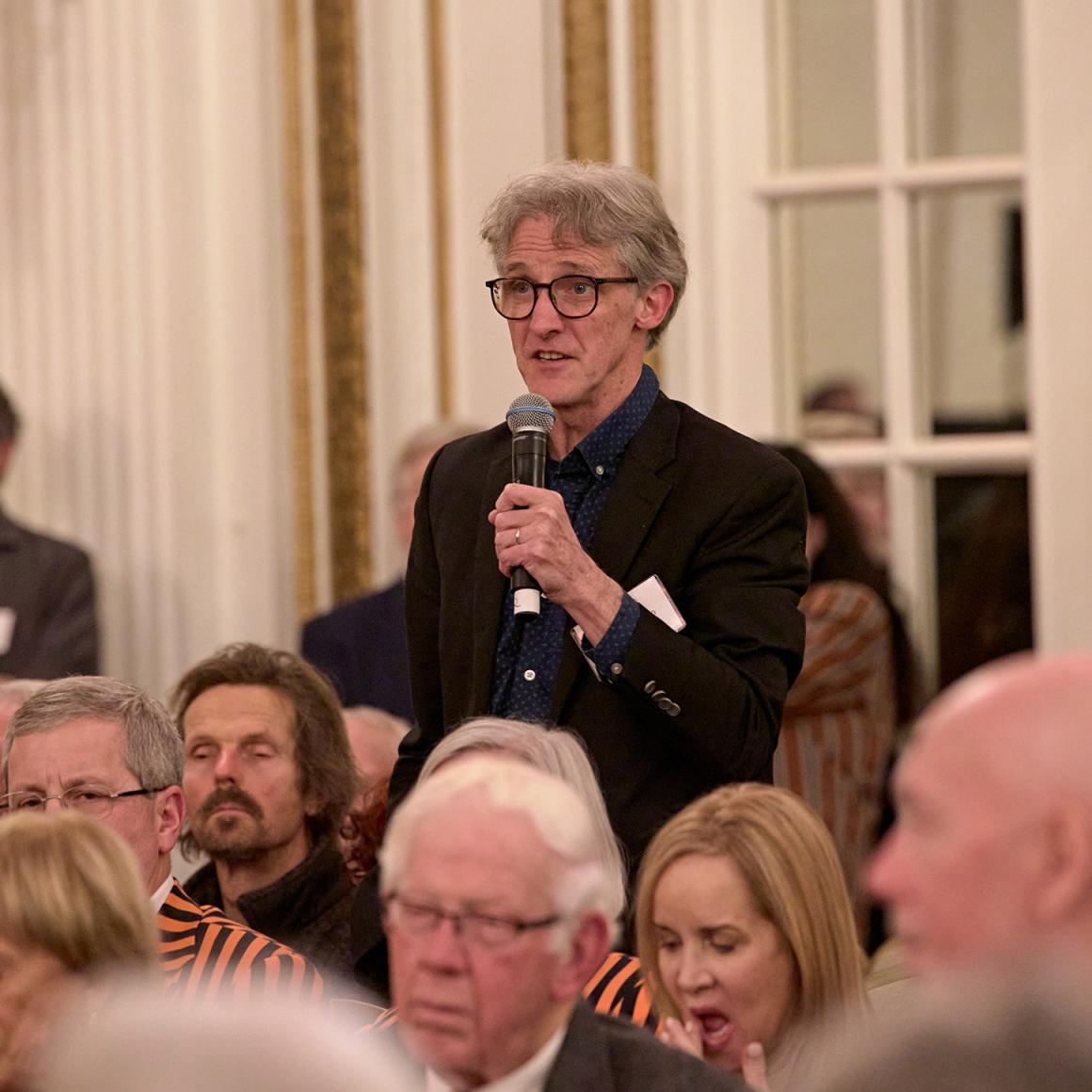 An alumnus asks an audience question during the Boston event.