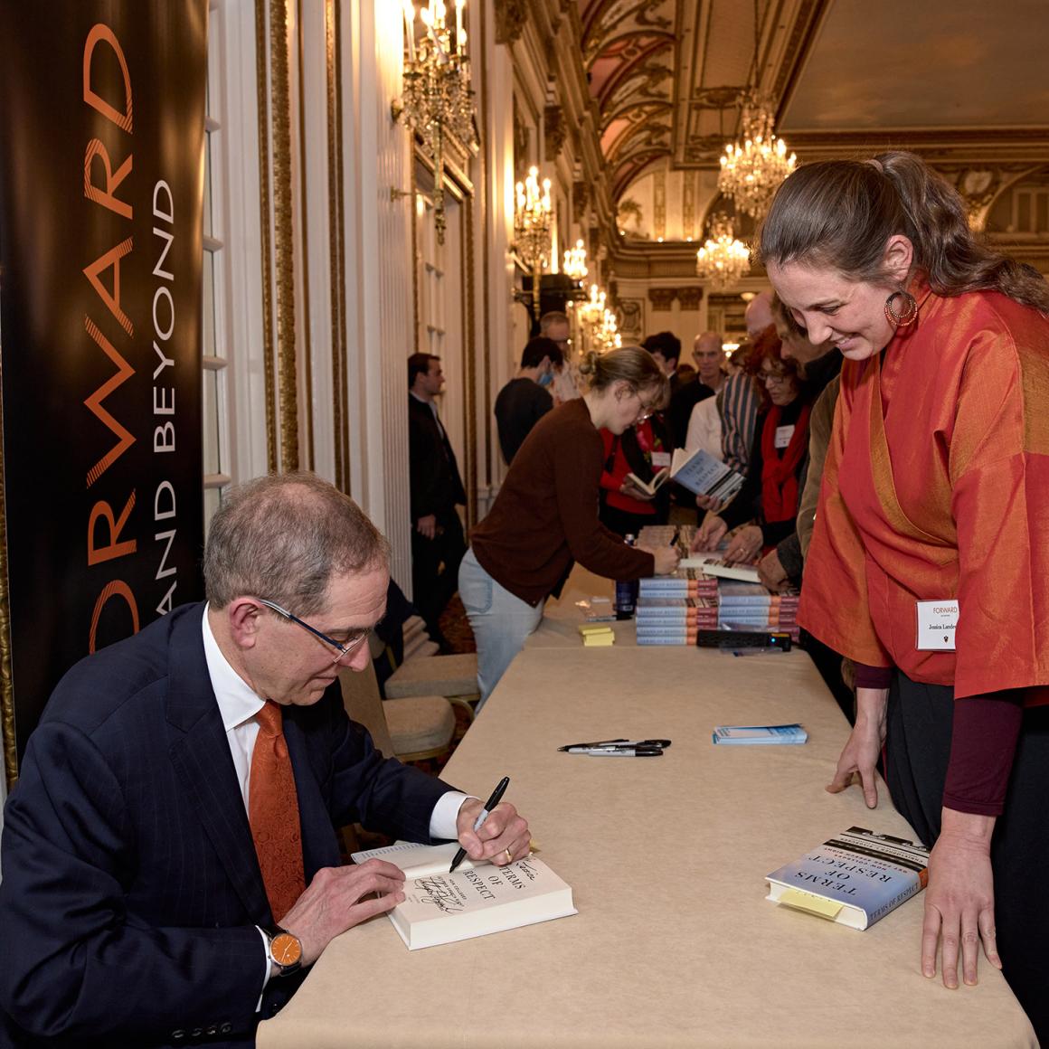President Eisgruber, signing a copy of his book for an alumna.