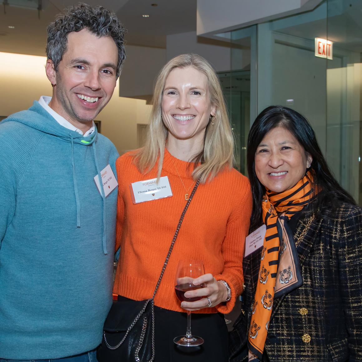 Three alumni dressed in bright orange.