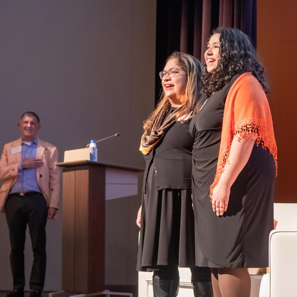 Two alumnae lead the audience in the singing of Old Nassau.