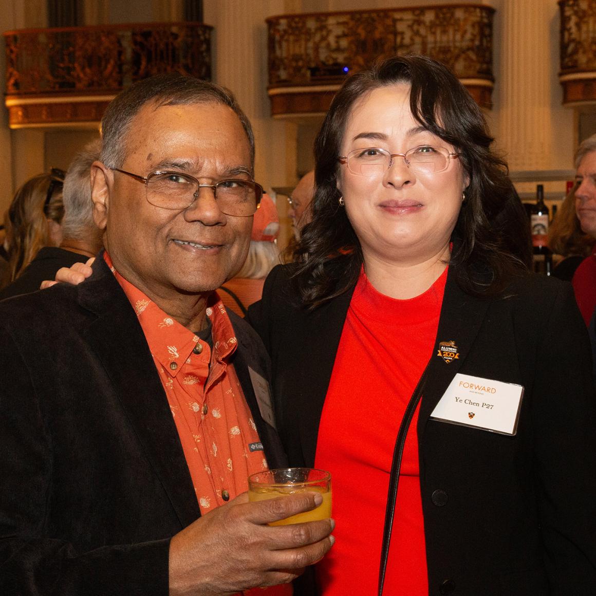 An alumni couple, dressed in bright orange