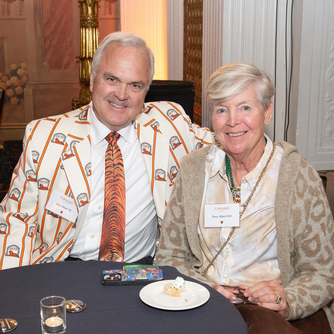 An alumni couple seated at a reception table. 