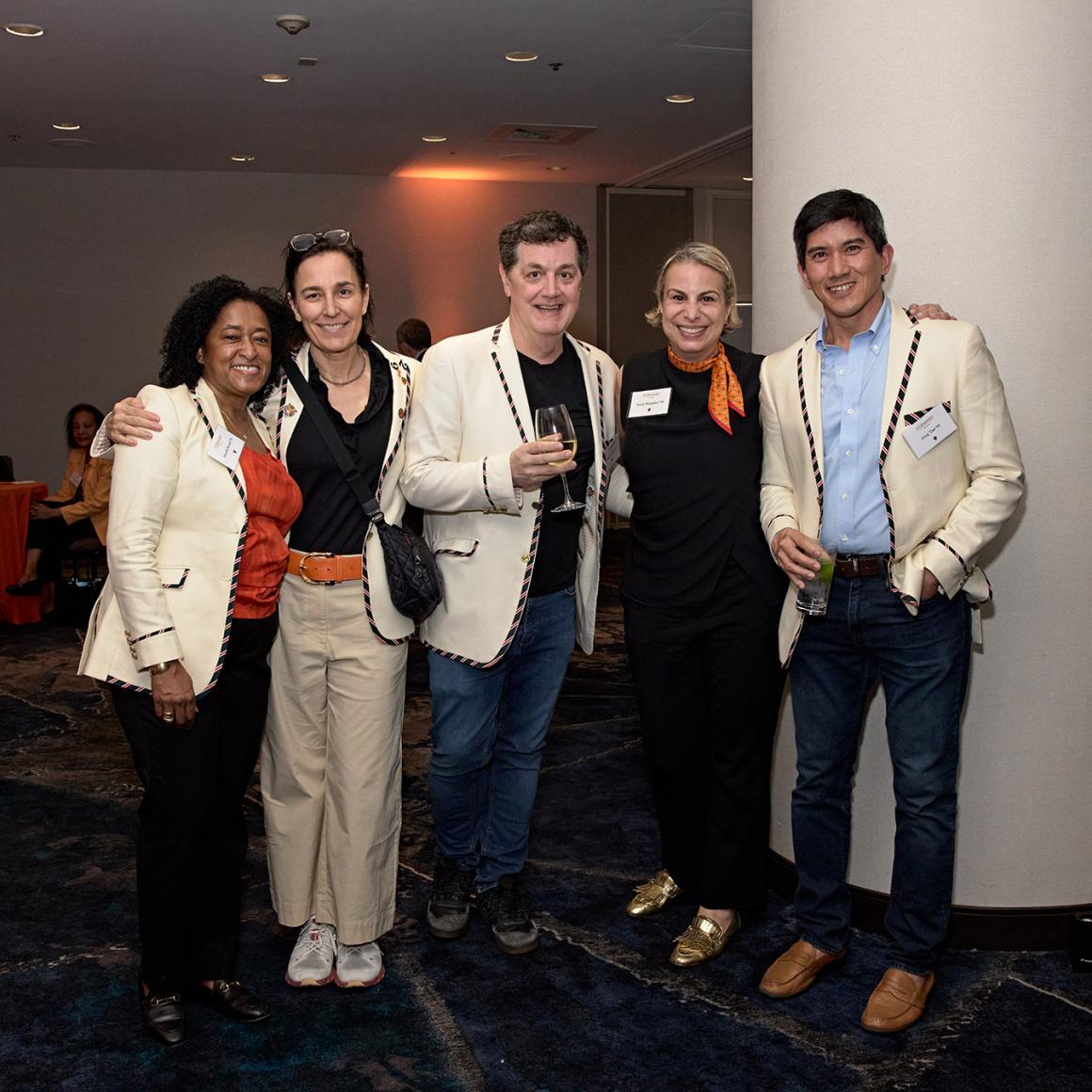 Five classmates in white Princeton class jackets pose shoulder to shoulder. 