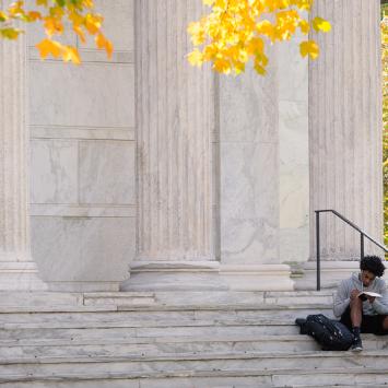 Student sitting on steps of Clio