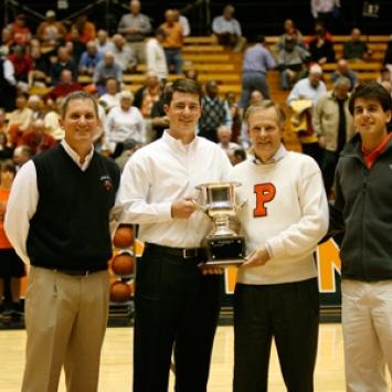Men’s golf coach Will Green, John Sawin ’06, Stu Francis ’74, and Greg Stamas ’10 with a Princeton-Penn alumni challenge trophy.
