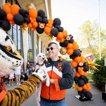 The Tiger mascot great an alumni, who is holding his dog, during Reunions