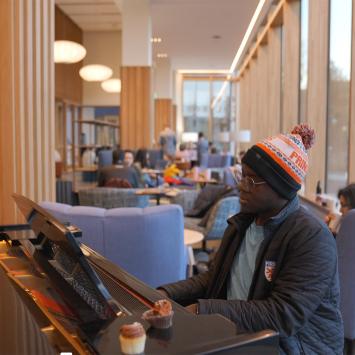 A Black Princeton student plays the piano in one of the new residential colleges