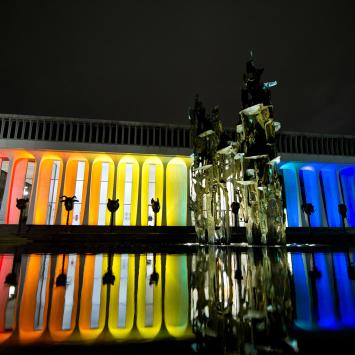 Robertson Hall at night, illuminated by rainbow lights