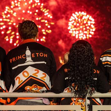 Three young alumni watch the fireworks at Reunions