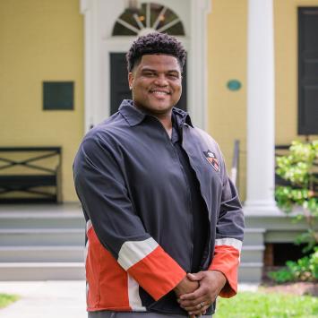 Eric Plummer from the Class of 2010, standing in front of Maclean House on the Princeton campus