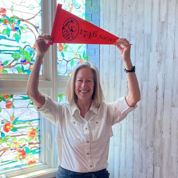 Beth Gilson holds a 1746 Society pennant