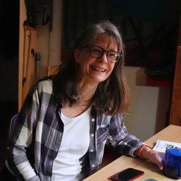 Mary Brunkow seated at her home desk, reacting to winning a Nobel.