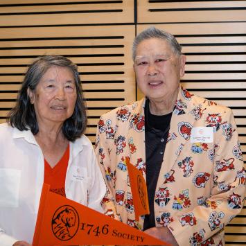 Kay and Leighton Chen, holding an orange Princeton pennant
