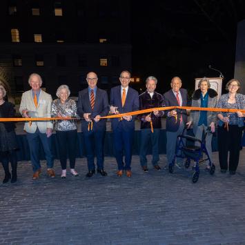University officials and alumni hold and cut an orange ribbon to dedicate the new Art Museum.