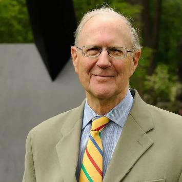 John Wilmerding, in tie and jacket, standing in front of the art installation near Prospect House.