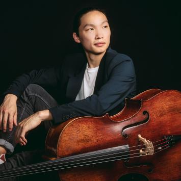 Leland Ko, sitting on the floor next to his cello