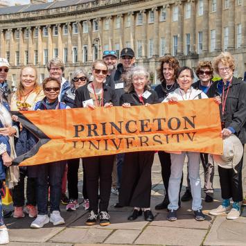 Princeton alumni and friends hold an orange Princeton banner in front of No. 1 Royal Crescent, part of the Jane Austen tour