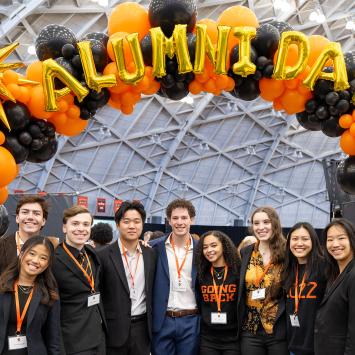 Group of alumni under a balloon arch