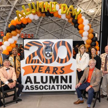 Ryan Ruskin and former chairs of the Alumni Council crowd around the form sculture celebrating the 200th anniversary of the Alumni Association.