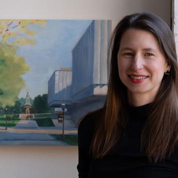 Headshot of Katherine Boyce with a painting behind her