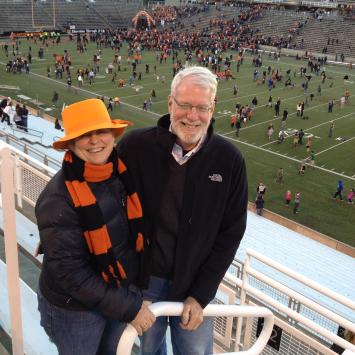 Bonnie Hewson and Chuck Marboe with a football stadium field in the background